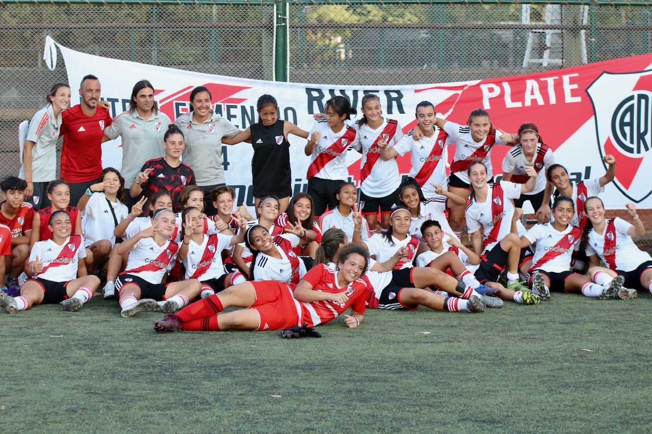 Un grupo de personas posando delante de un equipo de fútbol Descripción generada automáticamente
